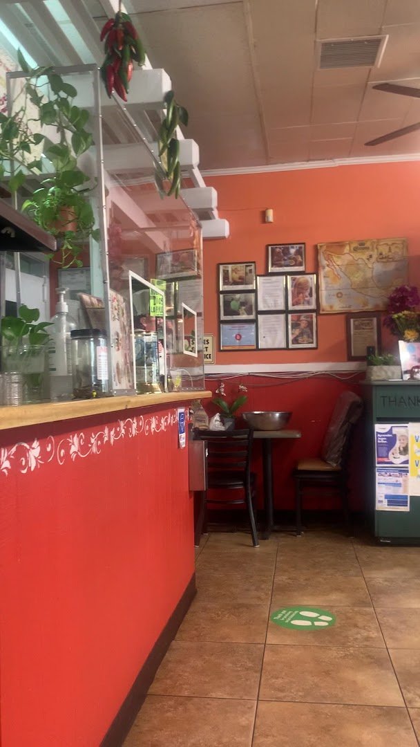 Simple restaurant interior with seating and bright menu boards.